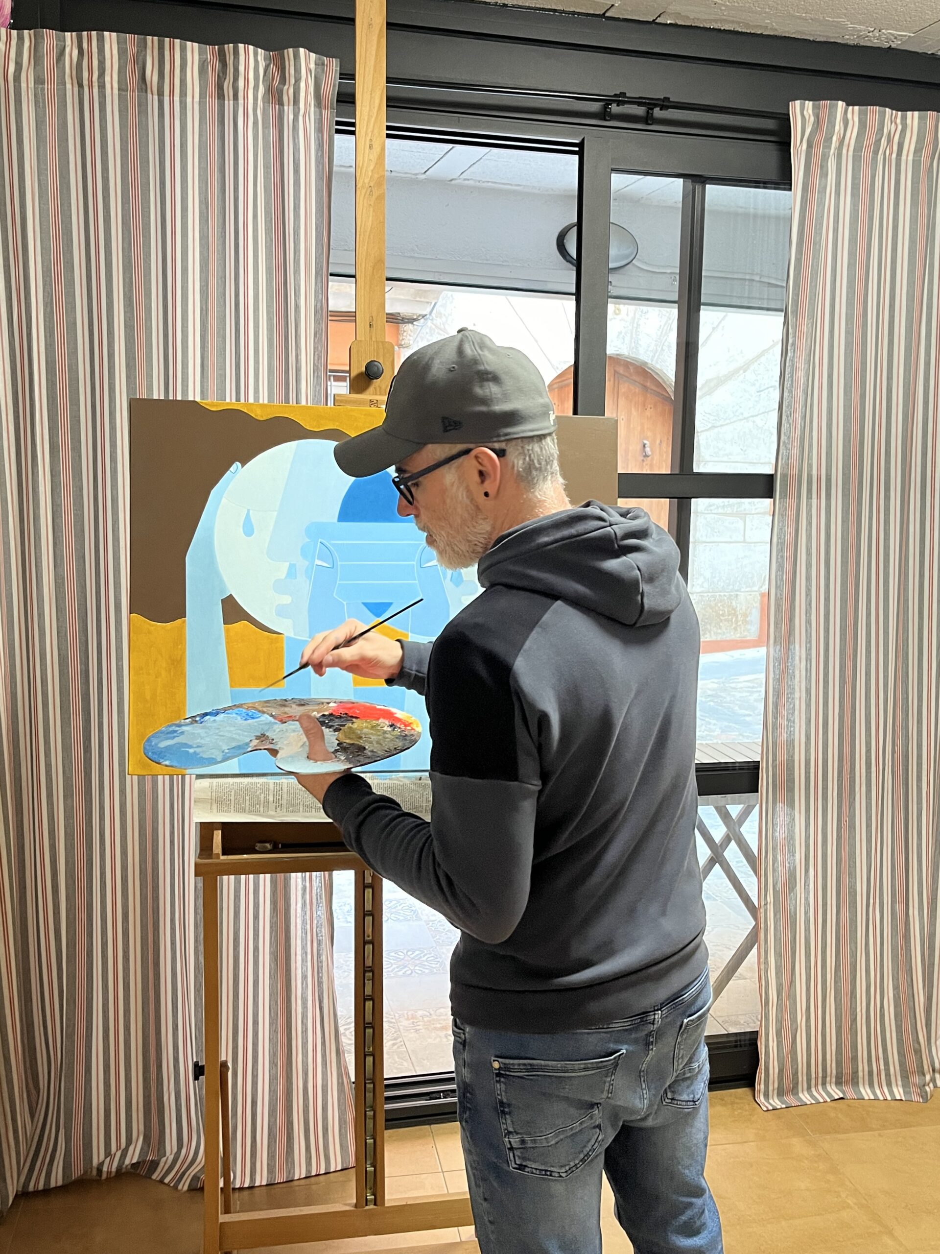 Geocubist surrealist artist Alex Carr painting in his studio.